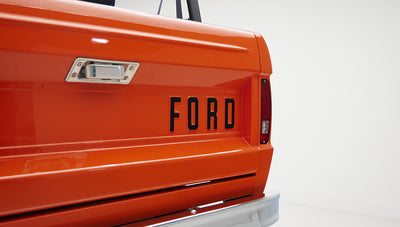 Close-up of orange tailgate with black FORD lettering on Classic Ford Bronco