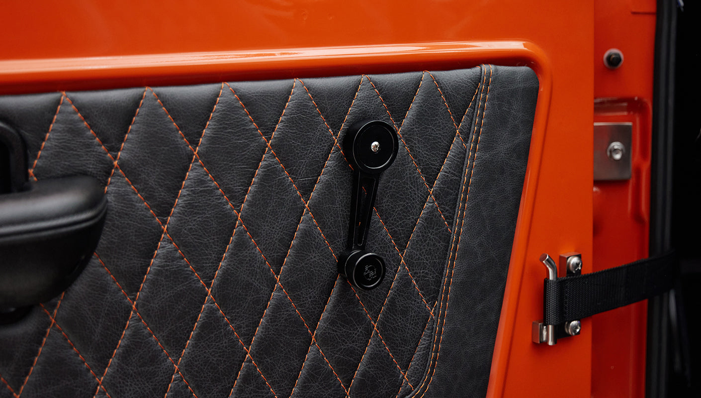 Quilted black and orange door panel with manual window crank in Classic Ford Bronco
