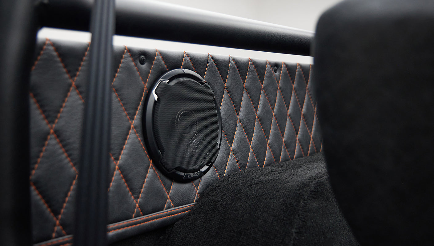 Kenwood speaker mounted on quilted black and orange interior panel of Classic Ford Bronco
