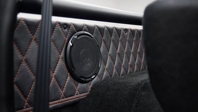 Kenwood speaker mounted on quilted black and orange interior panel of Classic Ford Bronco