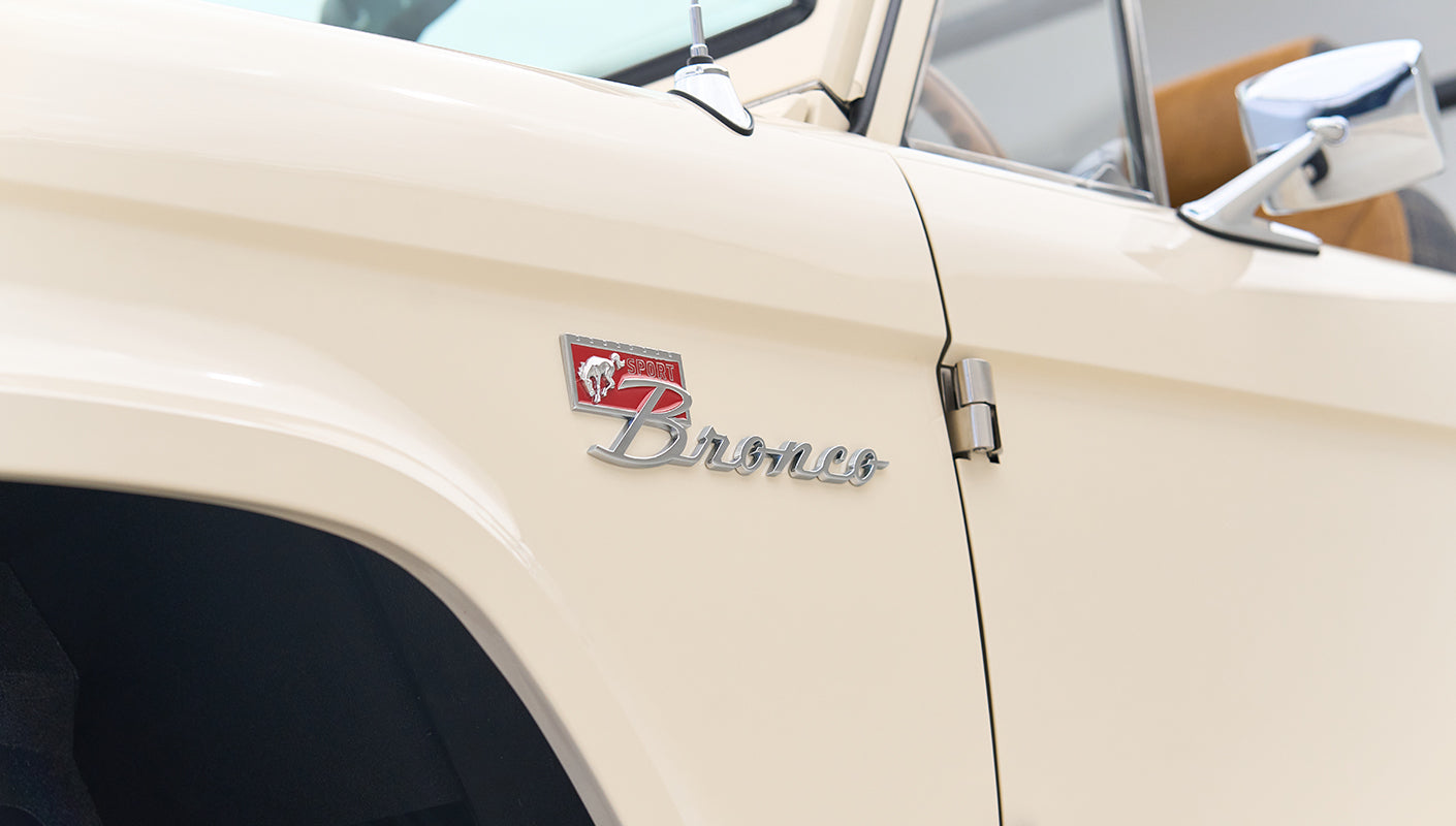 Cream-colored Classic Ford Bronco door panel with Sport Bronco emblem and side mirror