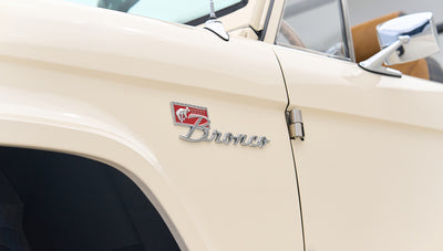 Cream-colored Classic Ford Bronco door panel with Sport Bronco emblem and side mirror
