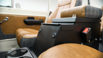Side view of center console with black lockbox and tan seats with plaid accents
