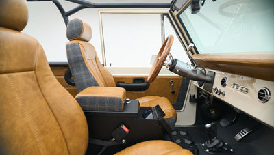 Side view of Classic Ford Bronco interior showing driver's seat, dashboard, and open door