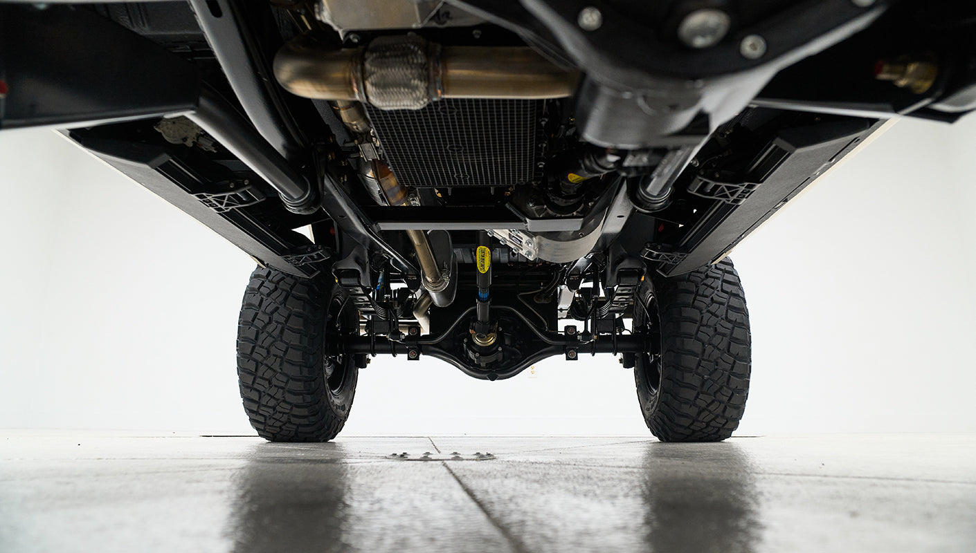 Front underside view showing differential, suspension, and exhaust pipes of a vehicle