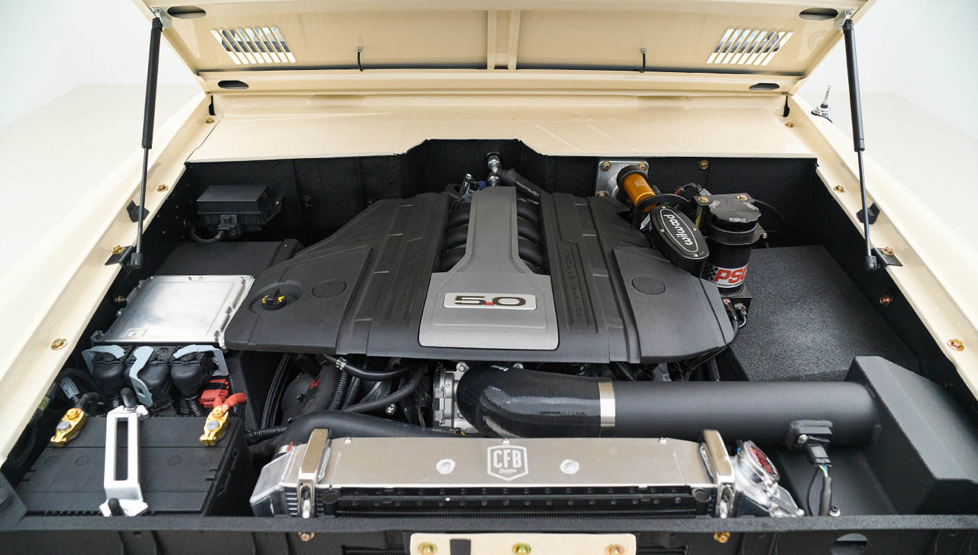 Engine bay angled view highlighting air filter, battery, and fluid reservoirs