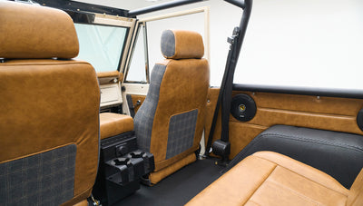 Interior rear view showing close-up of seats with tan and plaid upholstery and roll cage