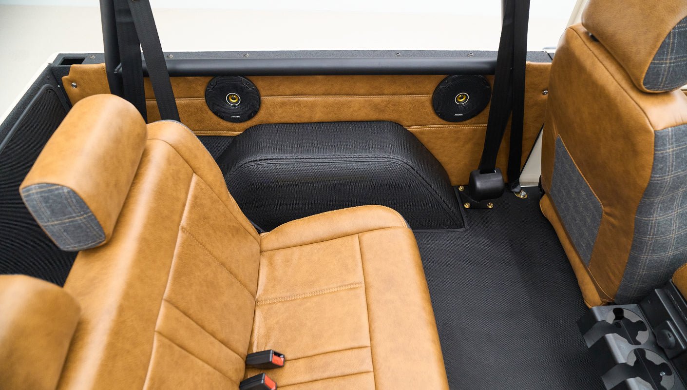Rear seats of Classic Ford Bronco with tan leather and speaker installation