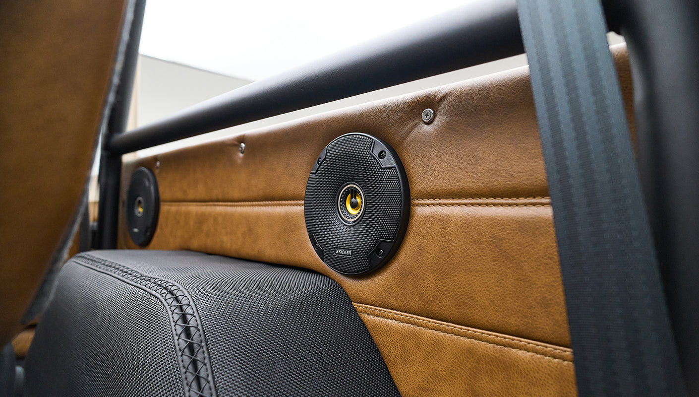 Close-up of speaker mounted in tan leather interior panel of Classic Ford Bronco