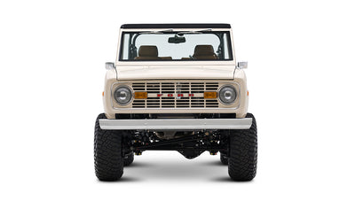 Front view of cream Classic Ford Bronco with off-road tires and black roll bars