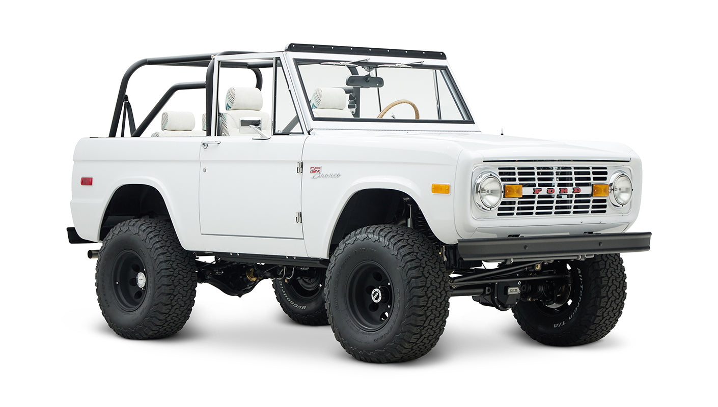 Classic Ford Bronco 1966 in white with open roof and off-road tires, front-side view