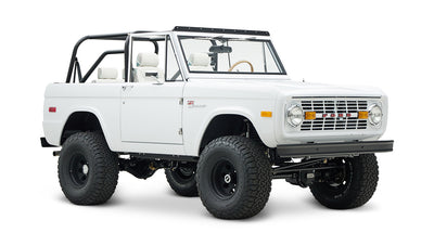 Classic Ford Bronco 1966 in white with open roof and off-road tires, front-side view