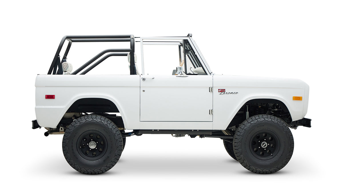 Opposite side view of Classic Ford Bronco with white body and black off-road wheels