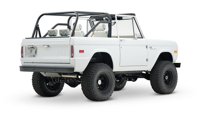 Classic Ford Bronco 1966 white open-top vehicle from rear-side angle with black wheels and tires