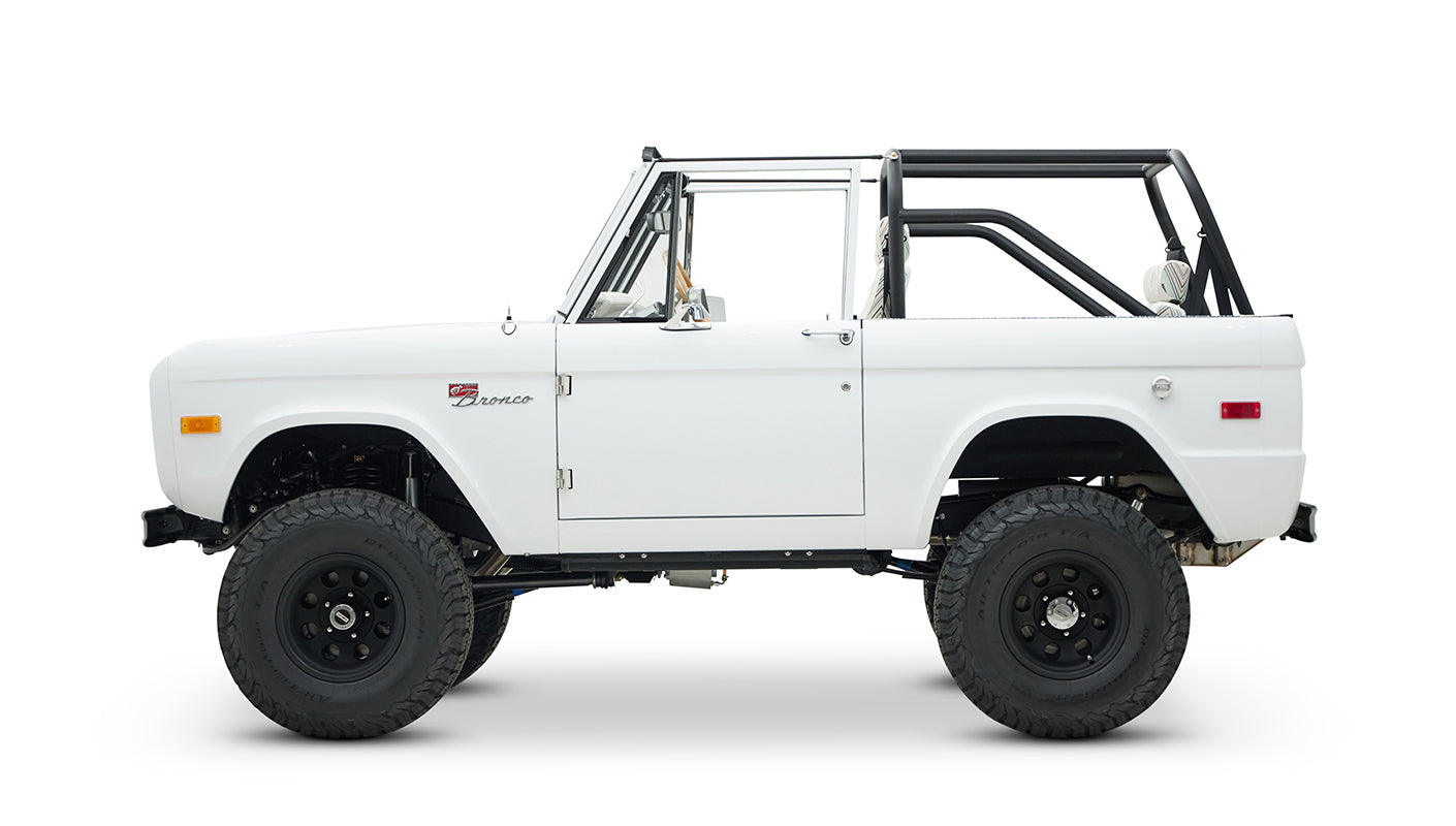 Side view of Classic Ford Bronco with white body and black off-road wheels