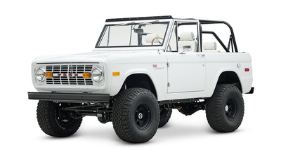 Classic Ford Bronco 1966 in white with black wheels and off-road tires shown front-side view
