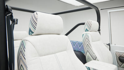 Two front bucket seats with white upholstery and patterned inserts in Classic Ford Bronco