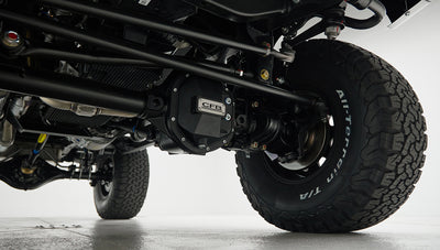 Undercarriage view focused on black differential with CFB badge and tire with white lettering
