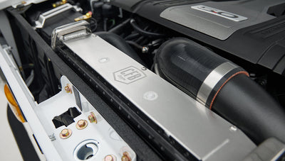 Close-up of PSC steering component with multiple black hoses attached in engine bay