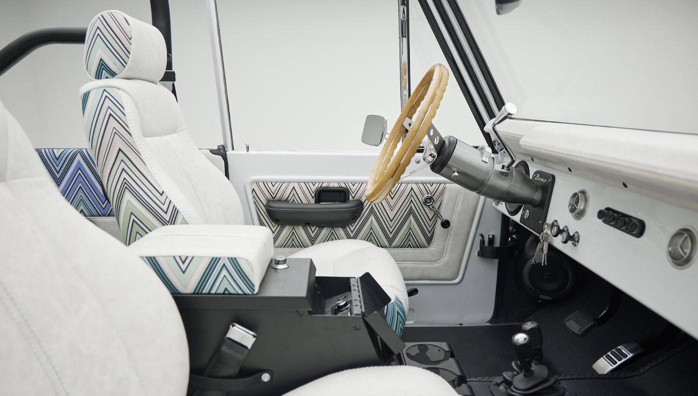 Classic Ford Bronco interior from passenger side showing dashboard, seats and steering wheel