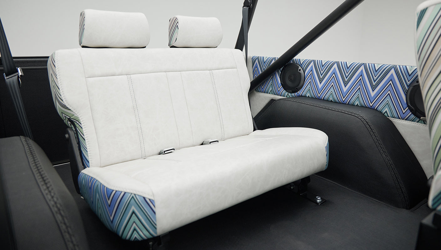 Rear bench seat close-up showing upholstery details and speakers in Classic Ford Bronco