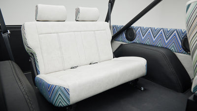 Rear bench seat close-up showing upholstery details and speakers in Classic Ford Bronco