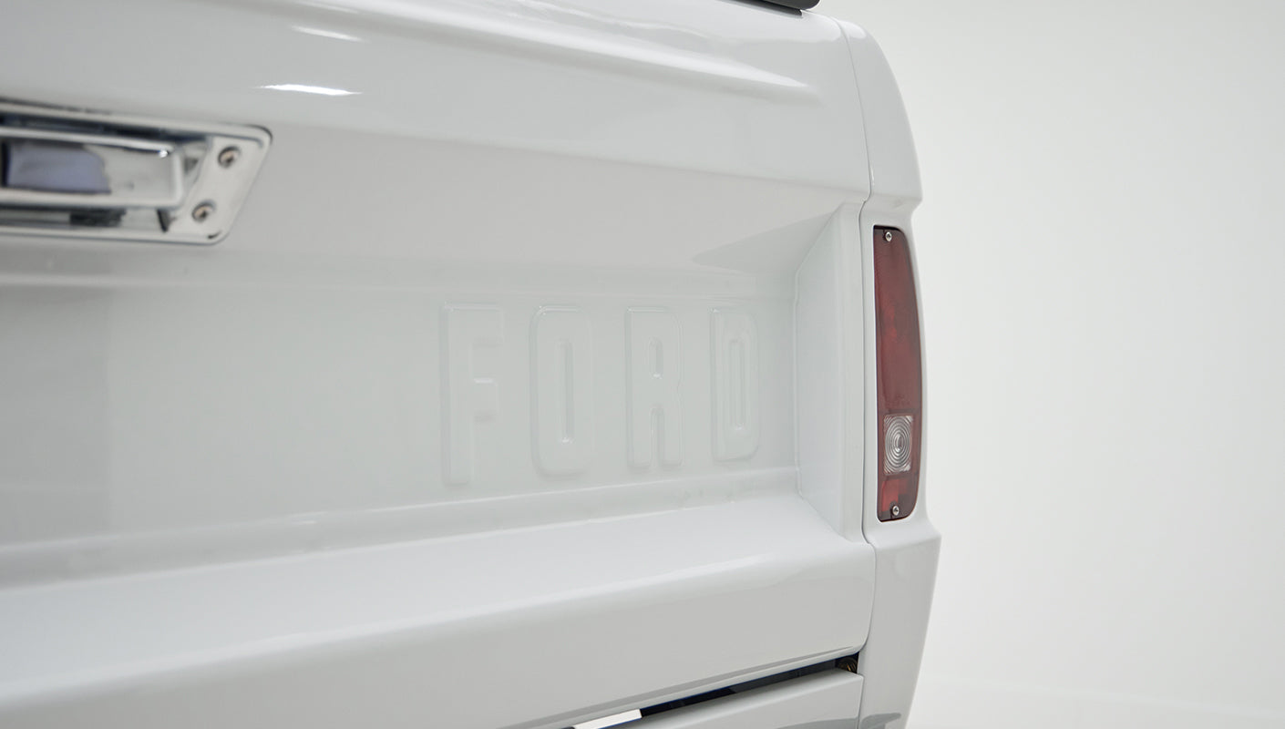 Close-up of rear tail light and FORD embossed tailgate on white Classic Ford Bronco