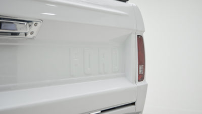 Close-up of rear tail light and FORD embossed tailgate on white Classic Ford Bronco