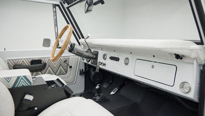 Classic Ford Bronco 1966 White Coyote Series interior with white and patterned seats and wooden steering wheel