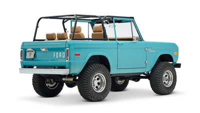 Classic Ford Bronco in Peacock Blue, tan interior, black roll cage seen from rear angled view