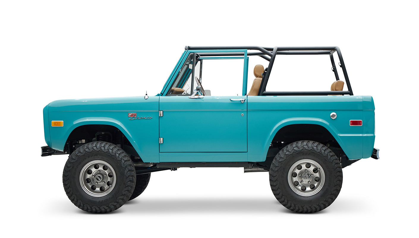 Side view of Classic Ford Bronco in Peacock Blue with tan seats and black roll cage