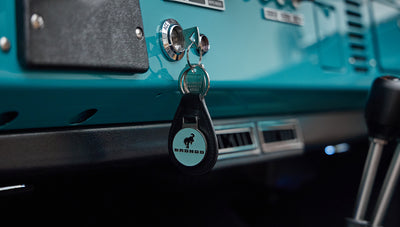 Bronco key in ignition with black and blue dashboard visible in peacock blue interior