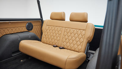 Rear tan leather bench seat with diamond pattern upholstery in classic Ford Bronco