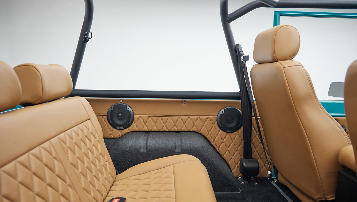 Passenger side front and rear tan leather seats with quilted design and black seat belts