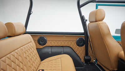 Passenger side front and rear tan leather seats with quilted design and black seat belts