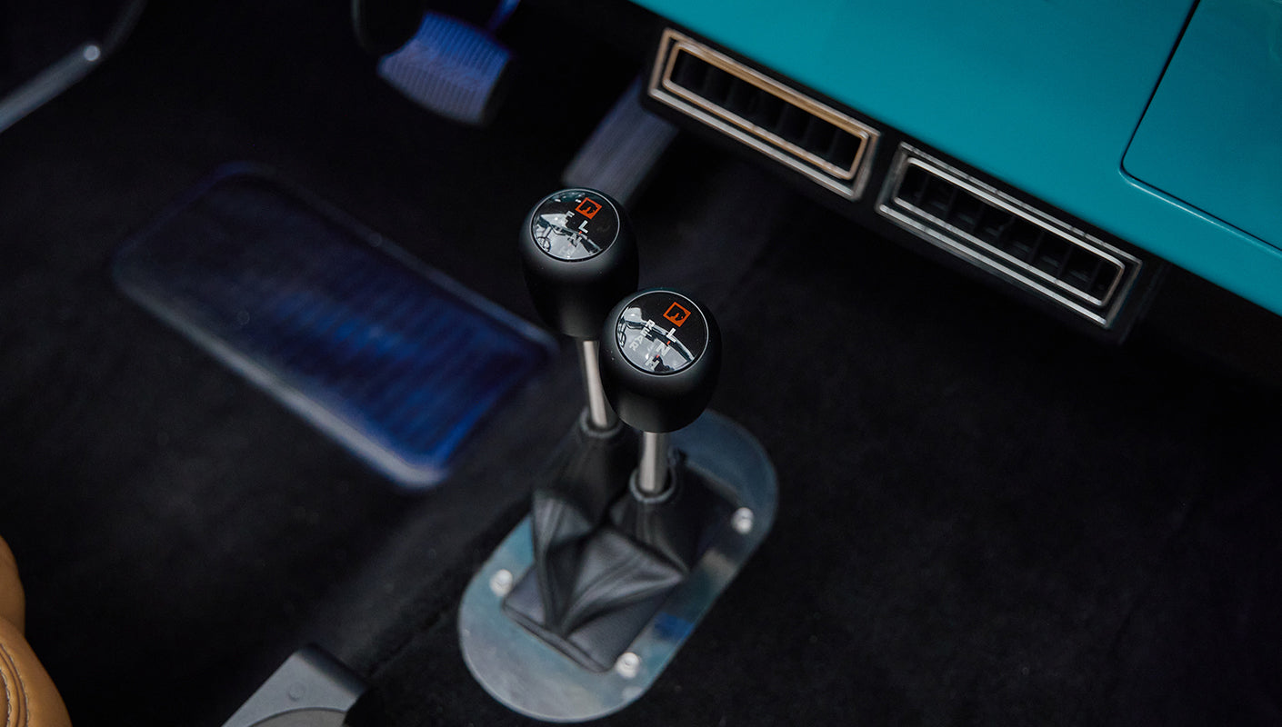 Two black gear shift levers with shift pattern detailing inside Classic Ford Bronco