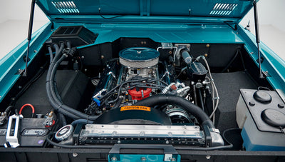 Open hood showing clean engine bay with blue paint and chrome components of Classic Ford Bronco