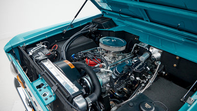 Close-up of Wilwood brake master cylinder and chrome Ford Racing valve covers in engine bay of Classic Ford Bronco