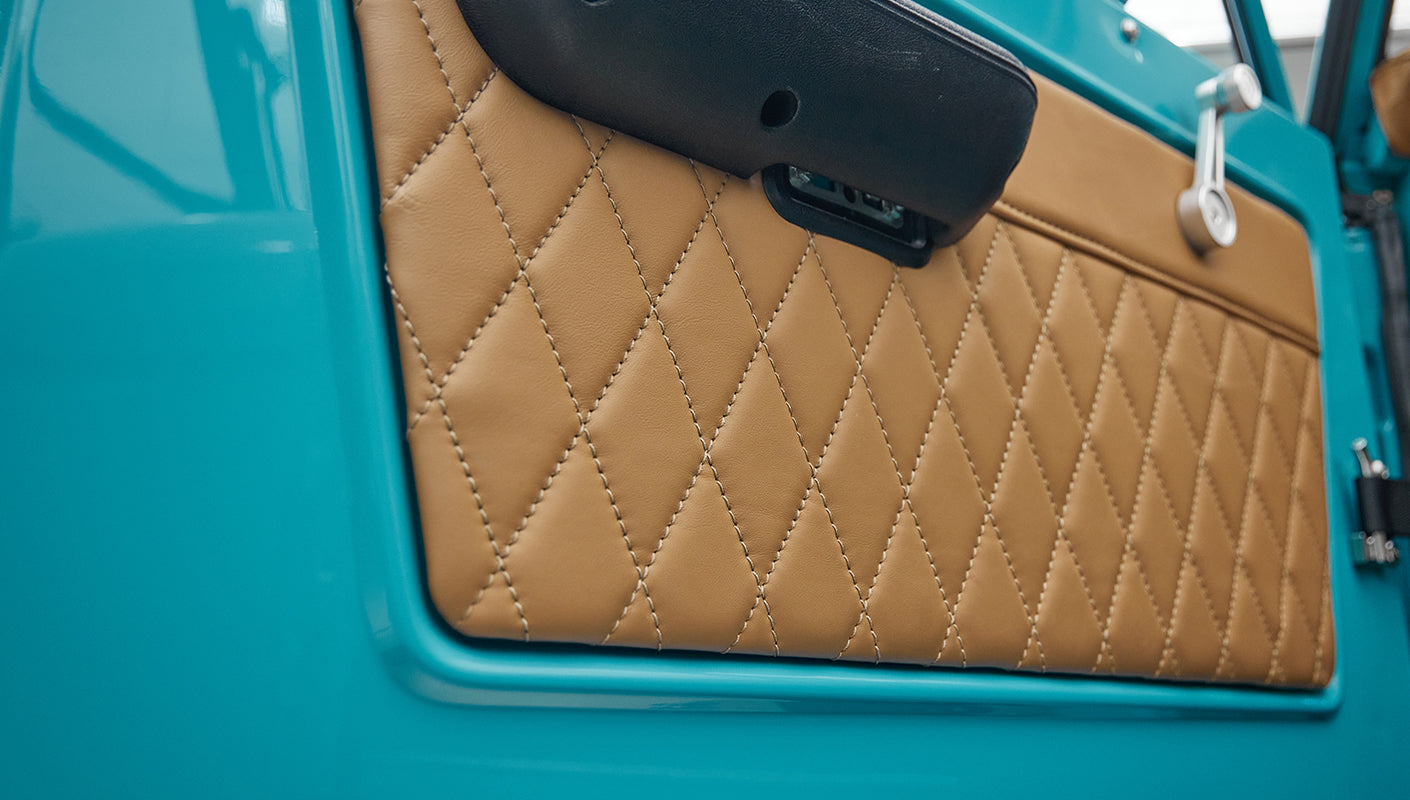 Close up of tan diamond-stitched leather door panel inside Classic Ford Bronco.