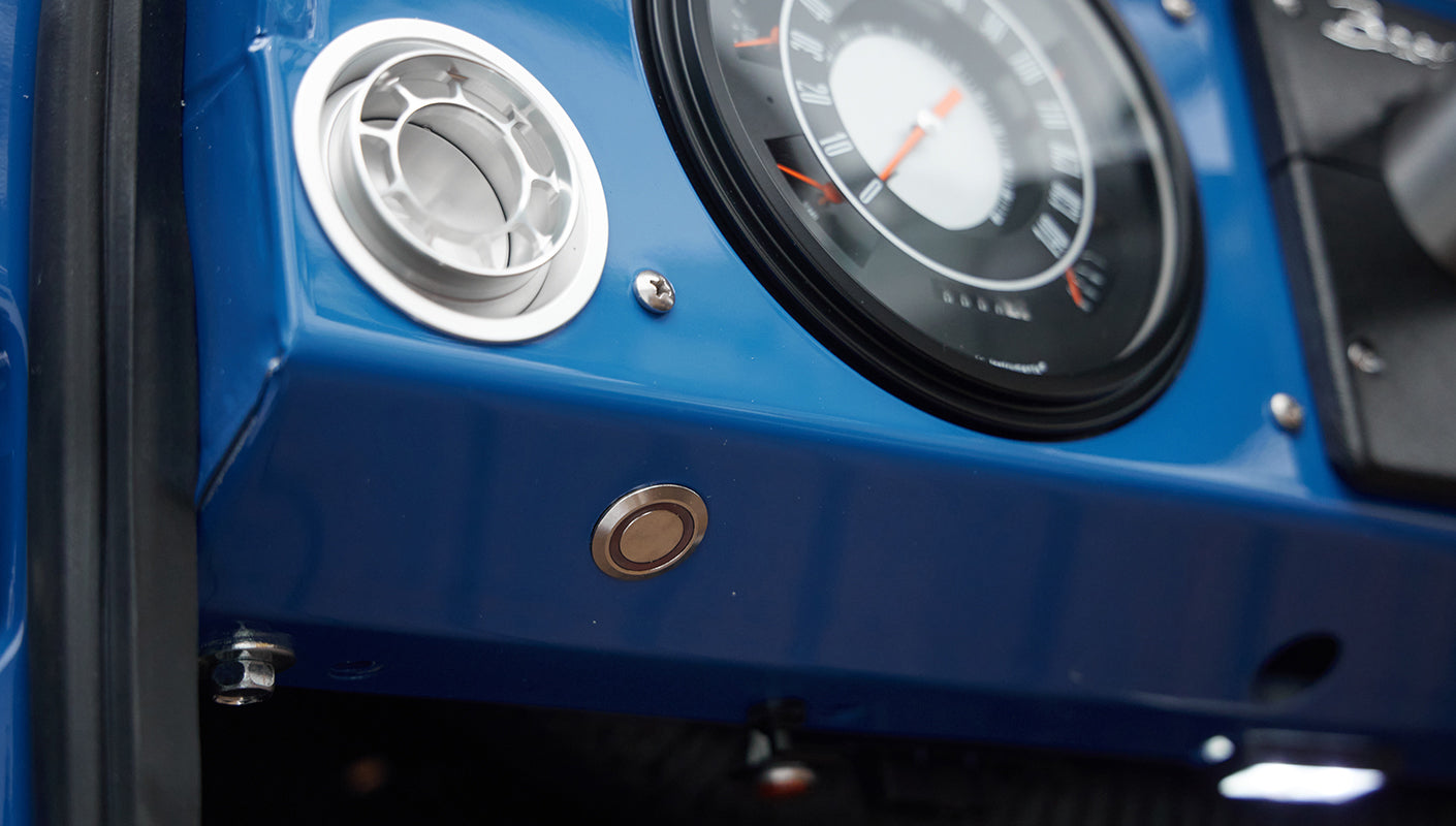 Blue dashboard panel with silver air vent and circular speedometer in Classic Ford Bronco