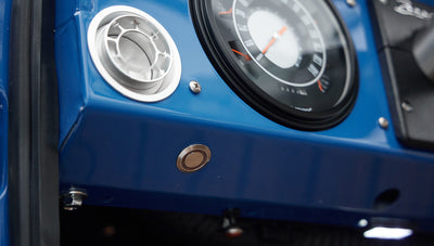 Blue dashboard panel with silver air vent and circular speedometer in Classic Ford Bronco