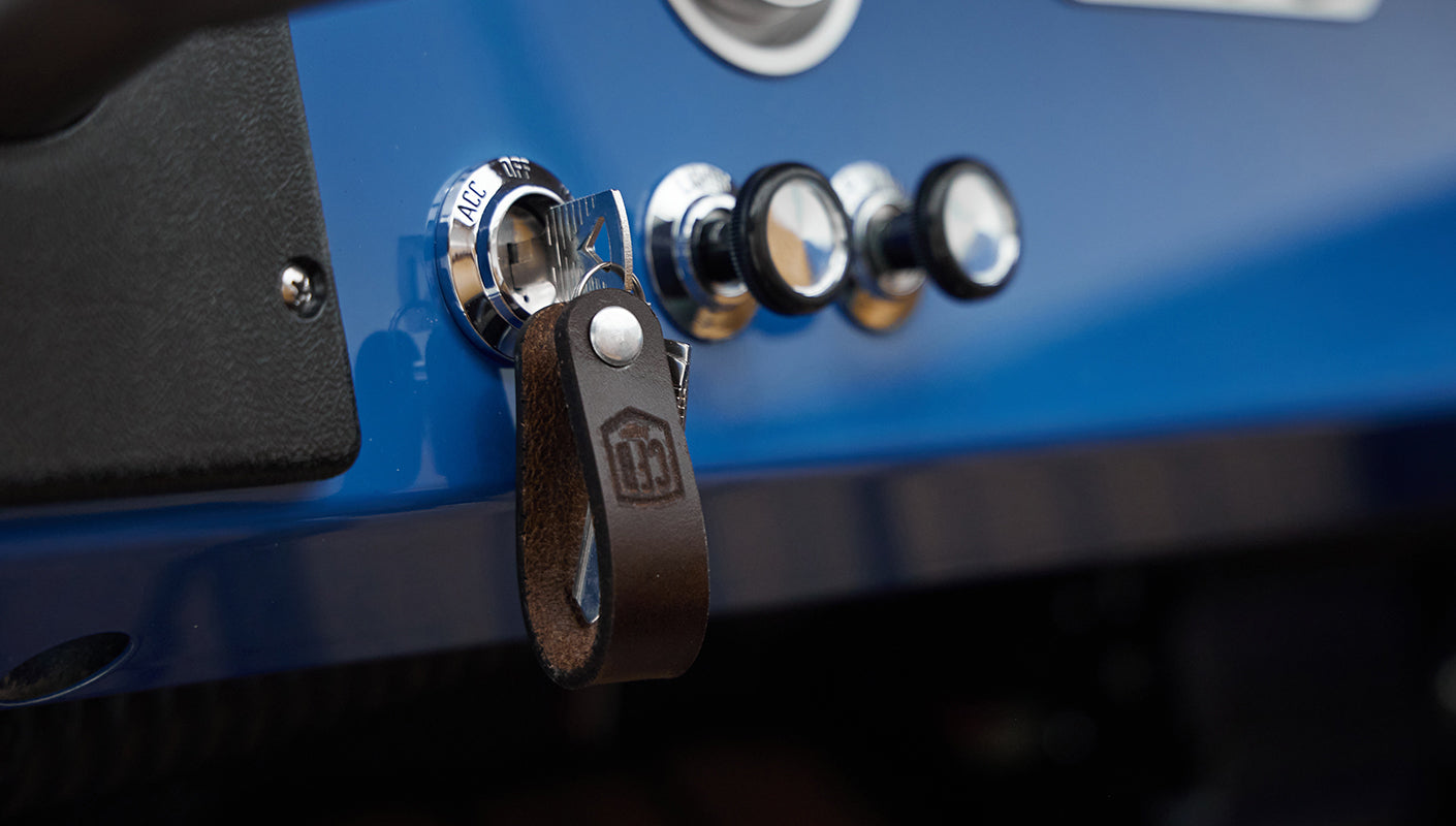 Close-up of Classic Ford Bronco ignition switch with leather key fob hanging from it