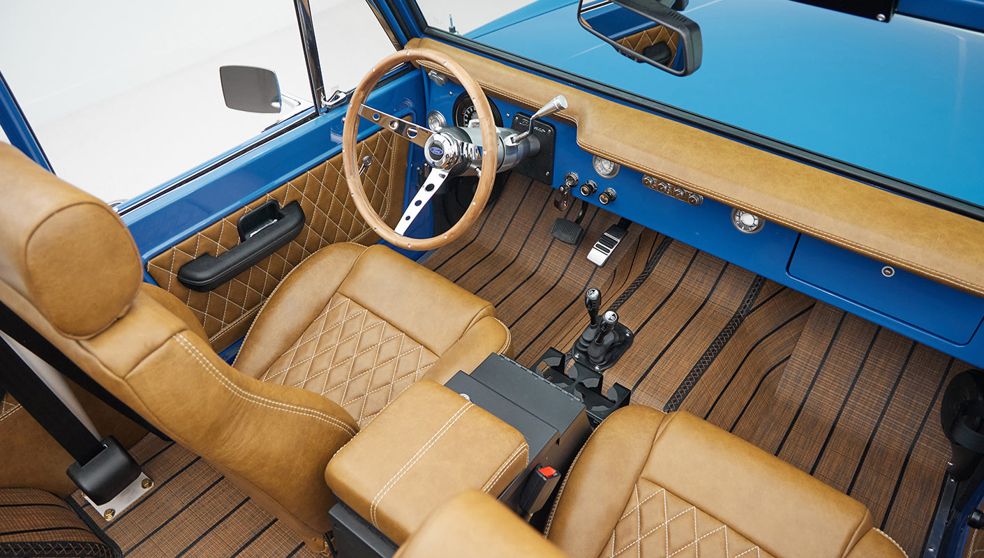 Overhead view of tan leather seats and center console with gear shifters inside Classic Ford Bronco