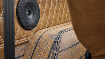 Close-up of tan diamond-stitched upholstery with a round speaker inside Classic Ford Bronco