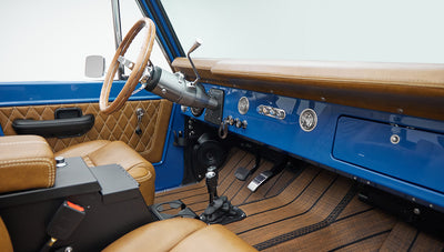 Dashboard and driver area of Classic Ford Bronco with tan leather and blue dashboard