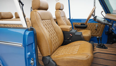 Side view of two tan leather front seats with diamond stitch pattern inside Classic Ford Bronco