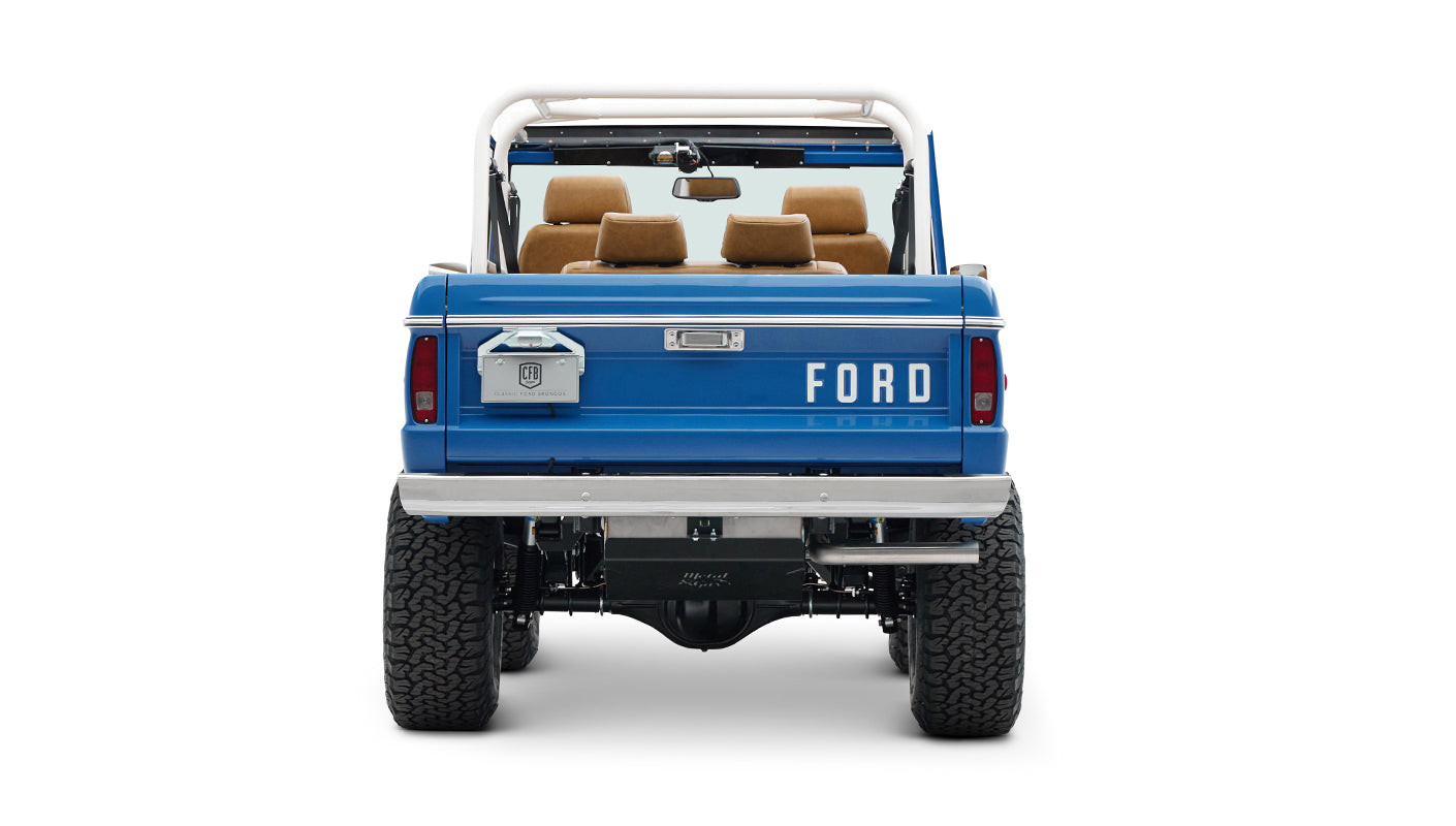 Rear view of a Classic Ford Bronco in Bahama Blue with tan interior and white roll cage