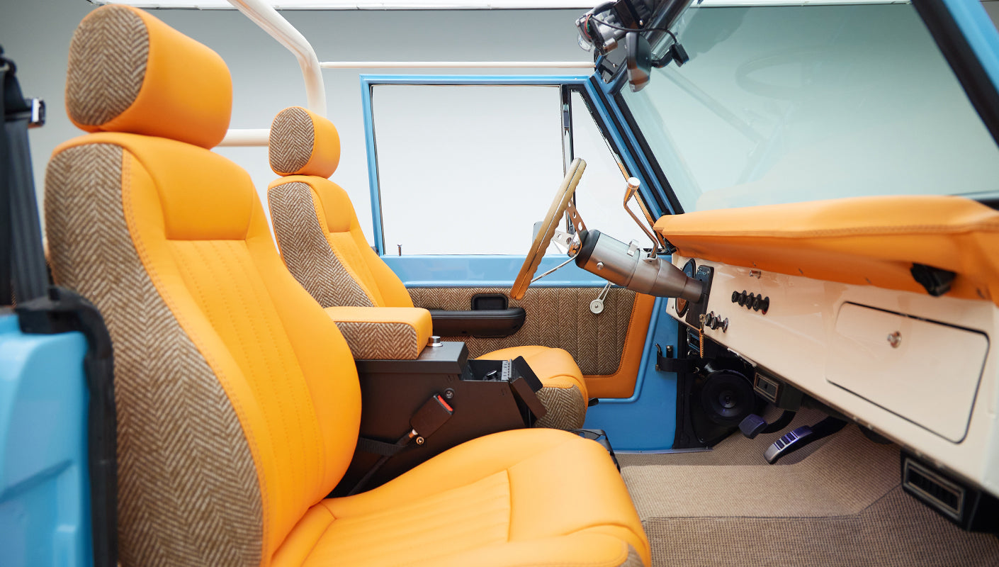 Orange seats and tan dashboard inside a Classic Ford Bronco