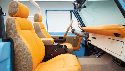 Orange seats and tan dashboard inside a Classic Ford Bronco