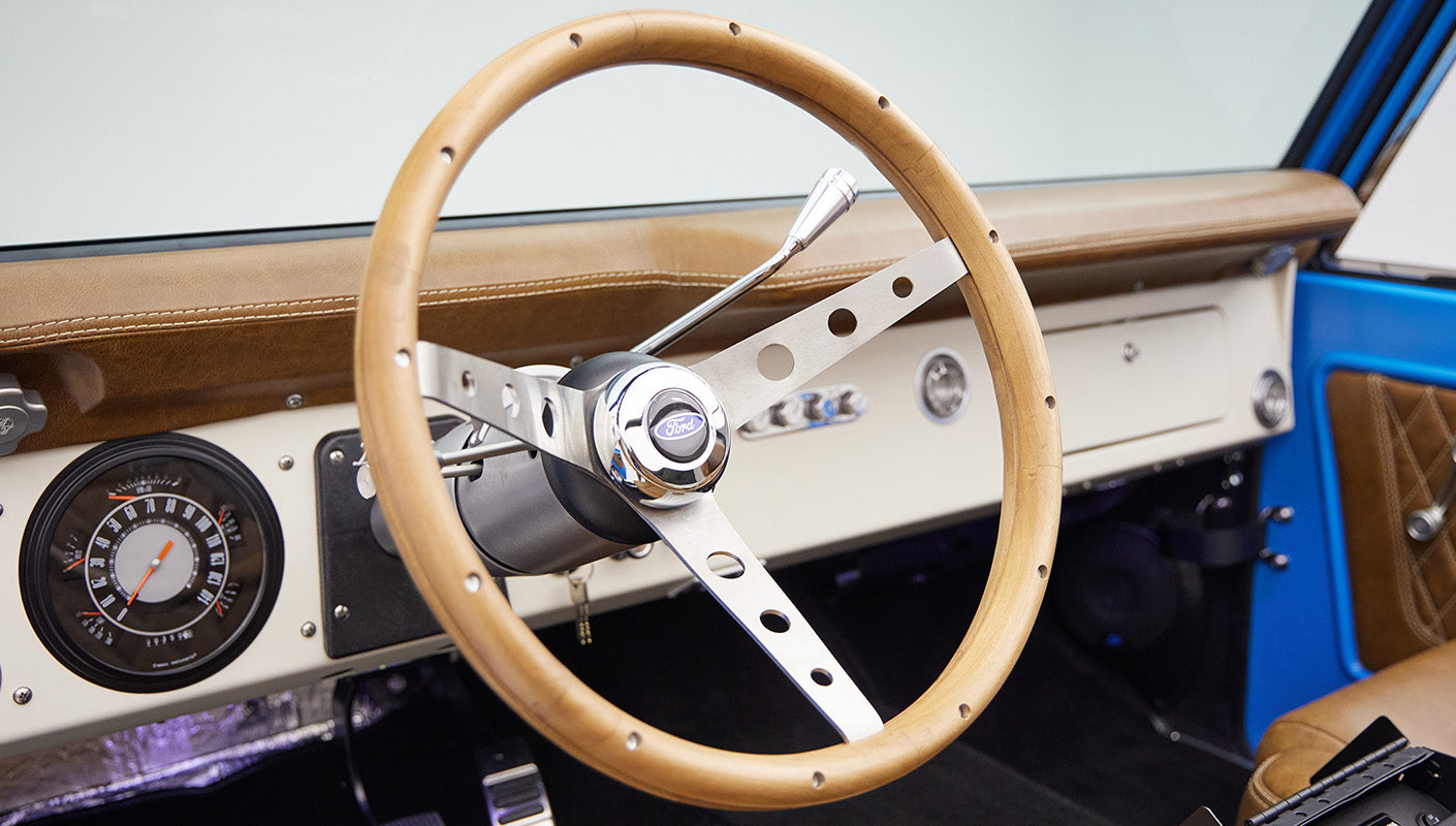 1976 classic ford bronco in blue patina paint with whiskey leather interior wood steering wheel detail